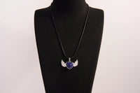 Raw Earth Crystals lapis lazuli heart with wings necklace, featuring a deep blue heart-shaped stone adorned with delicate angelic wings, designed to enhance wisdom, promote self-expression, and support spiritual insight.