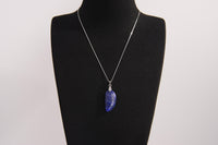 Raw Earth Crystals lapis lazuli pendant featuring an etched design, crafted from natural stone to promote truth, inner wisdom, and spiritual connection.