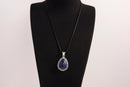 Raw Earth Crystals lapis lazuli pendant with a teardrop-shaped design, featuring natural lapis lazuli and an ornate silver-tone setting, promoting wisdom, truth, and spiritual insight.