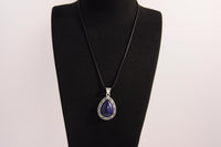 Raw Earth Crystals lapis lazuli pendant with a teardrop-shaped design, featuring natural lapis lazuli and an ornate silver-tone setting, promoting wisdom, truth, and spiritual insight.