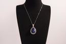 Raw Earth Crystals lapis lazuli pendant with a teardrop-shaped design, featuring natural lapis lazuli and an ornate silver-tone setting, promoting wisdom, truth, and spiritual insight.