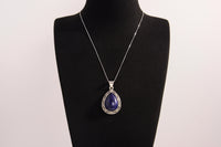 Raw Earth Crystals lapis lazuli pendant with a teardrop-shaped design, featuring natural lapis lazuli and an ornate silver-tone setting, promoting wisdom, truth, and spiritual insight.