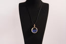 Raw Earth Crystals lapis pendant with a crystal-encased design, featuring natural lapis lazuli and gold-tone setting, promoting wisdom, communication, and inner truth.