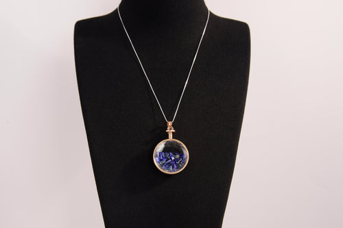 Raw Earth Crystals lapis pendant with a crystal-encased design, featuring natural lapis lazuli and gold-tone setting, promoting wisdom, communication, and inner truth.