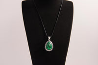 Raw Earth Crystals malachite pendant with a teardrop-shaped design, featuring natural malachite and an ornate silver-tone setting, promoting transformation, abundance, and emotional healing.