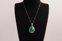 Raw Earth Crystals malachite pendant with a teardrop-shaped design, featuring natural malachite and an ornate silver-tone setting, promoting transformation, abundance, and emotional healing.