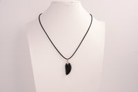Raw Earth Crystals obsidian angel wing pendant, featuring a polished black obsidian stone carved into an elegant wing shape and set on a silver-tone chain, promoting protection, grounding, and spiritual connection.