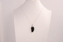 Raw Earth Crystals obsidian angel wing pendant, featuring a polished black obsidian stone carved into an elegant wing shape and set on a silver-tone chain, promoting protection, grounding, and spiritual connection.