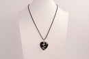 Raw Earth Crystals obsidian heart pendant with an elegant rose design, featuring a sleek black obsidian stone and a silver-tone vine with leaves, promoting protection, grounding, and emotional strength.