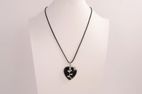 Raw Earth Crystals obsidian heart pendant with an elegant rose design, featuring a sleek black obsidian stone and a silver-tone vine with leaves, promoting protection, grounding, and emotional strength.