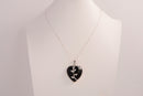 Raw Earth Crystals obsidian heart pendant with an elegant rose design, featuring a sleek black obsidian stone and a silver-tone vine with leaves, promoting protection, grounding, and emotional strength.