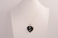 Raw Earth Crystals obsidian heart pendant with an elegant rose design, featuring a sleek black obsidian stone and a silver-tone vine with leaves, promoting protection, grounding, and emotional strength.