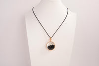 Raw Earth Crystals obsidian pendant with a crystal-encased design, featuring natural obsidian and gold-tone setting, promoting protection, grounding, and emotional balance.