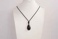 Raw Earth Crystals obsidian teardrop pendant on black cord, crafted from natural obsidian stone, promoting protection, grounding, and emotional clarity.