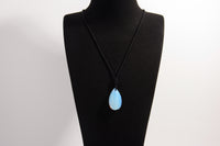 Raw Earth Crystals opal teardrop pendant on black cord, made from natural opal stone, enhancing intuition, emotional healing, and inner clarity.