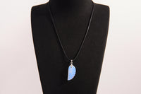 Raw Earth Crystals opalite angel wing pendant, featuring a delicate blue opalite stone carved into an elegant wing shape and set on a silver-tone chain, promoting calmness, spiritual connection, and emotional healing.
