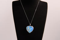 Raw Earth Crystals opalite heart pendant with an elegant rose design, featuring a soft blue opalite stone and a silver-tone vine with leaves, promoting calmness, emotional healing, and spiritual insight.