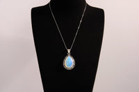 Raw Earth Crystals opalite pendant with a teardrop-shaped design, featuring natural opalite and an ornate silver-tone setting, enhancing emotional balance, intuition, and spiritual connection.