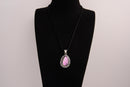 Raw Earth Crystals pink agate pendant with a teardrop-shaped design, featuring natural pink agate and an ornate silver-tone setting, promoting emotional balance, self-love, and gentle energy.