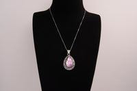 Raw Earth Crystals pink agate pendant with a teardrop-shaped design, featuring natural pink agate and an ornate silver-tone setting, promoting emotional balance, self-love, and gentle energy.
