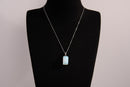 Raw Earth Crystals rectangle pendant featuring a polished opalite cabochon set in a sleek silver-toned bail, symbolizing serenity, emotional balance, and spiritual insight.