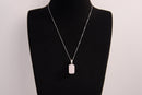 Raw Earth Crystals rectangle pendant featuring a polished rose quartz cabochon set in a sleek silver-toned bail, symbolizing love, compassion, and emotional healing.