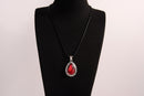 Raw Earth Crystals red agate pendant with a teardrop-shaped design, featuring natural red agate and an ornate silver-tone setting, promoting courage, vitality, and emotional strength.
