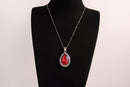 Raw Earth Crystals red agate pendant with a teardrop-shaped design, featuring natural red agate and an ornate silver-tone setting, promoting courage, vitality, and emotional strength.