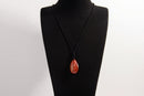 Raw Earth Crystals red jasper teardrop pendant on black cord, made from natural red jasper stone, supporting strength, courage, and emotional balance.