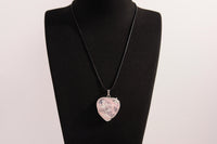 Raw Earth Crystals rose quartz heart pendant with an elegant rose design, featuring a soft pink rose quartz stone and a silver-tone vine with leaves, promoting love, compassion, and emotional healing.