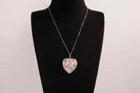 Raw Earth Crystals rose quartz heart pendant with an elegant rose design, featuring a soft pink rose quartz stone and a silver-tone vine with leaves, promoting love, compassion, and emotional healing.