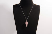 Raw Earth Crystals rose quartz pendant with a spiral wire wrap design, crafted from natural stone to foster love, compassion, and emotional healing.