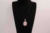 Raw Earth Crystals rose quartz pendant with a teardrop-shaped design, featuring natural rose quartz and an ornate silver-tone setting, promoting love, compassion, and emotional healing.