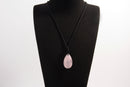 Raw Earth Crystals rose quartz teardrop pendant on black cord, crafted from natural rose quartz stone, promoting love, compassion, and emotional healing.