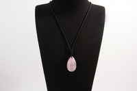 Raw Earth Crystals rose quartz teardrop pendant on black cord, crafted from natural rose quartz stone, promoting love, compassion, and emotional healing.
