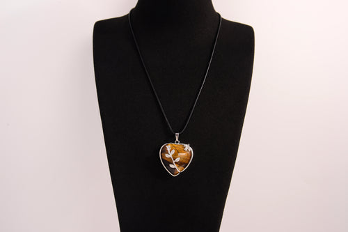 Raw Earth Crystals tiger eye heart pendant with an elegant rose design, featuring a rich golden-brown tiger eye stone and a silver-tone vine with leaves, promoting confidence, clarity, and personal power.