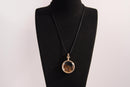 Raw Earth Crystals tiger eye pendant with a crystal-encased design, featuring natural tiger eye and gold-tone setting, supporting confidence, clarity, and personal power.