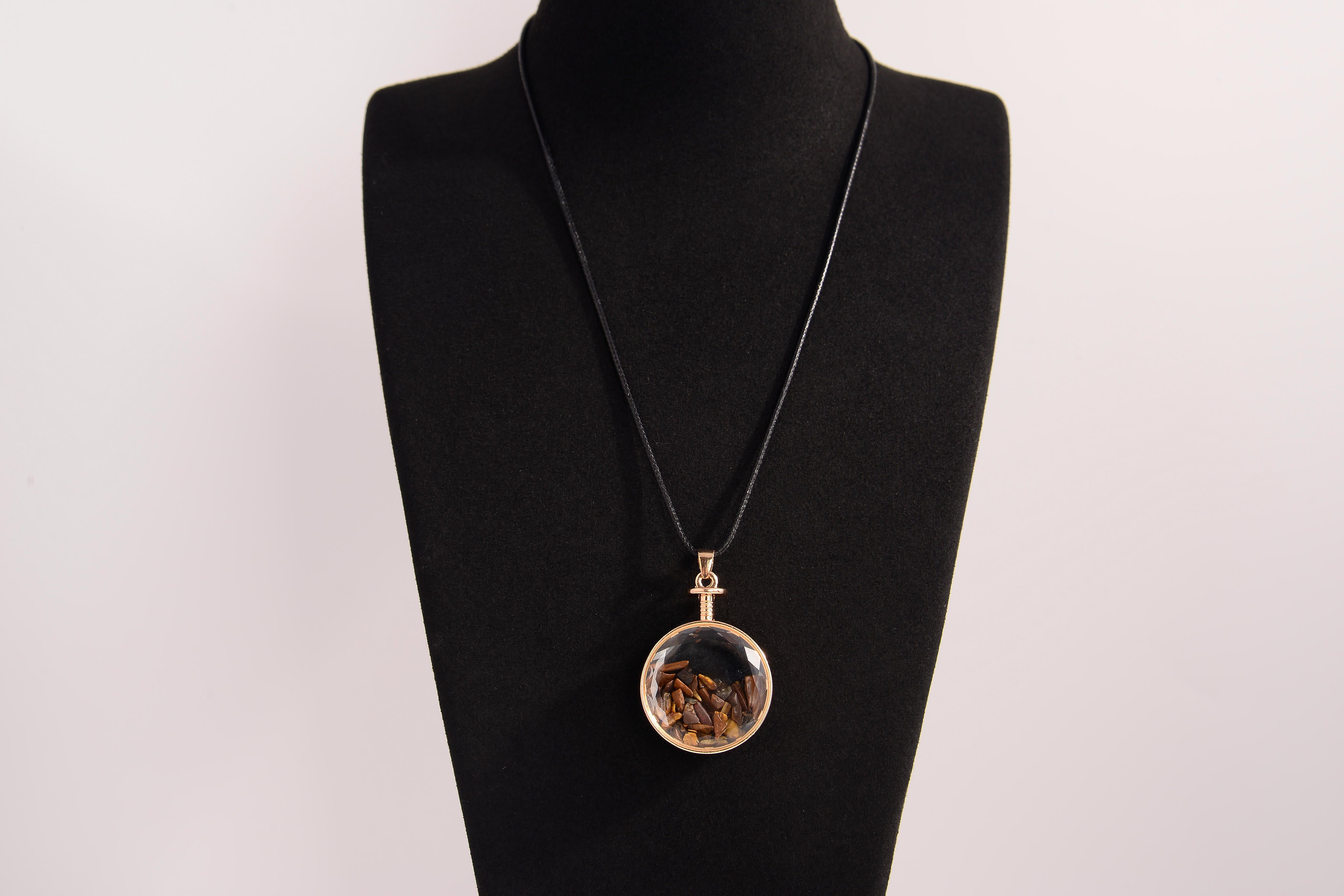 Raw Earth Crystals tiger eye pendant with a crystal-encased design, featuring natural tiger eye and gold-tone setting, supporting confidence, clarity, and personal power.