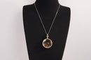 Raw Earth Crystals tiger eye pendant with a crystal-encased design, featuring natural tiger eye and gold-tone setting, supporting confidence, clarity, and personal power.