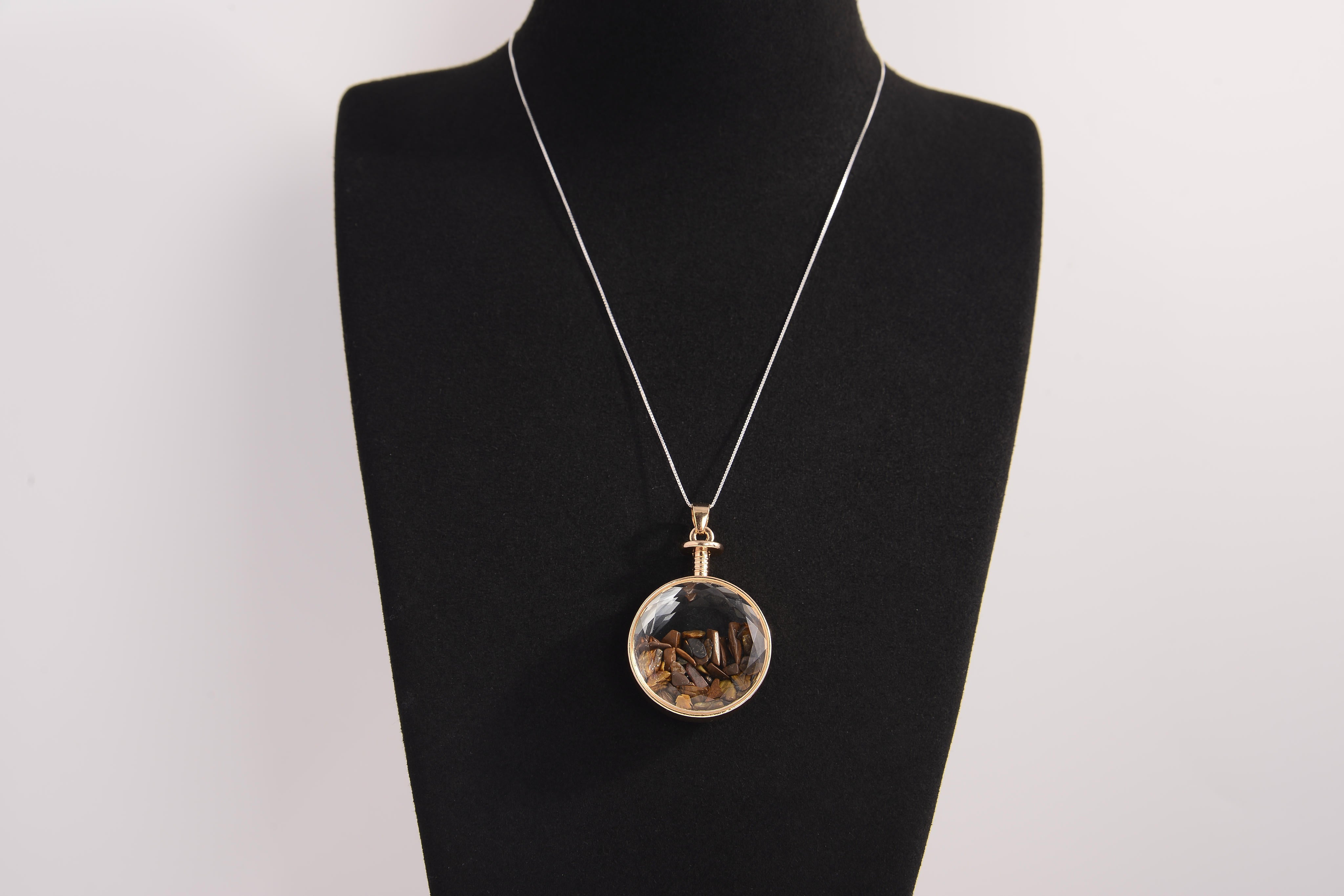 Raw Earth Crystals tiger eye pendant with a crystal-encased design, featuring natural tiger eye and gold-tone setting, supporting confidence, clarity, and personal power.