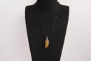 Raw Earth Crystals tiger eye pendant featuring an etched design, crafted from natural stone to promote balance, protection, and clarity.