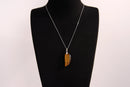 Raw Earth Crystals tiger eye pendant featuring an etched design, crafted from natural stone to promote balance, protection, and clarity.