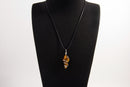 Raw Earth Crystals tiger eye pendant with a spiral wire wrap design, crafted from natural stone to promote confidence, protection, and grounding energy.