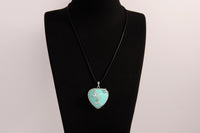 Raw Earth Crystals turquoise heart pendant with an elegant rose design, featuring a vibrant turquoise stone and a silver-tone vine with leaves, promoting communication, creativity, and emotional balance.