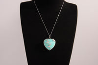 Raw Earth Crystals turquoise heart pendant with an elegant rose design, featuring a vibrant turquoise stone and a silver-tone vine with leaves, promoting communication, creativity, and emotional balance.