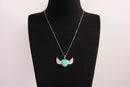 Raw Earth Crystals turquoise heart with wings necklace, featuring a vibrant blue-green heart-shaped stone adorned with delicate angelic wings, designed to promote communication, emotional balance, and spiritual protection.